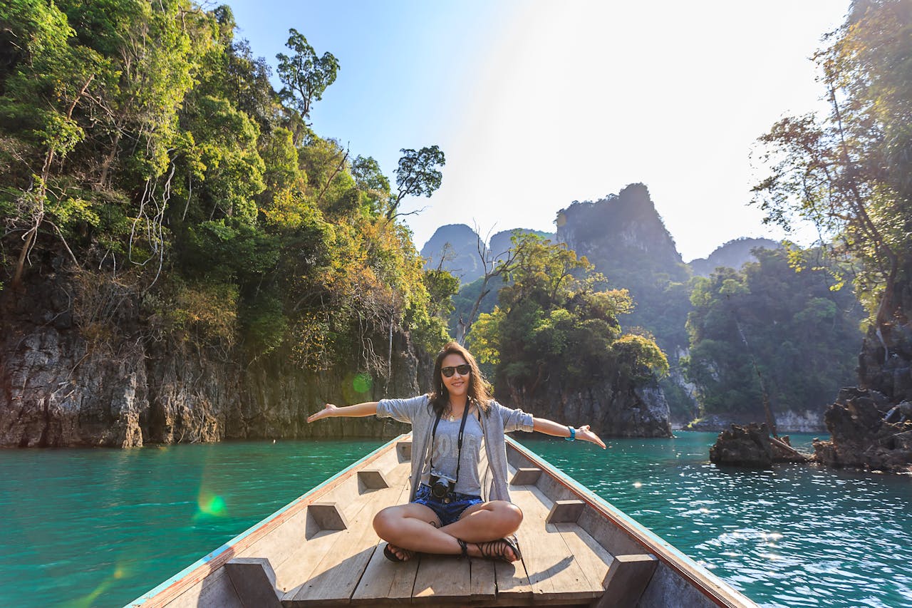 The Art of Drawing Readers In: Your attractive post title goes here Asian woman relishing a serene boat journey through the lush karst landscape of Thailand's Khlong Sok.